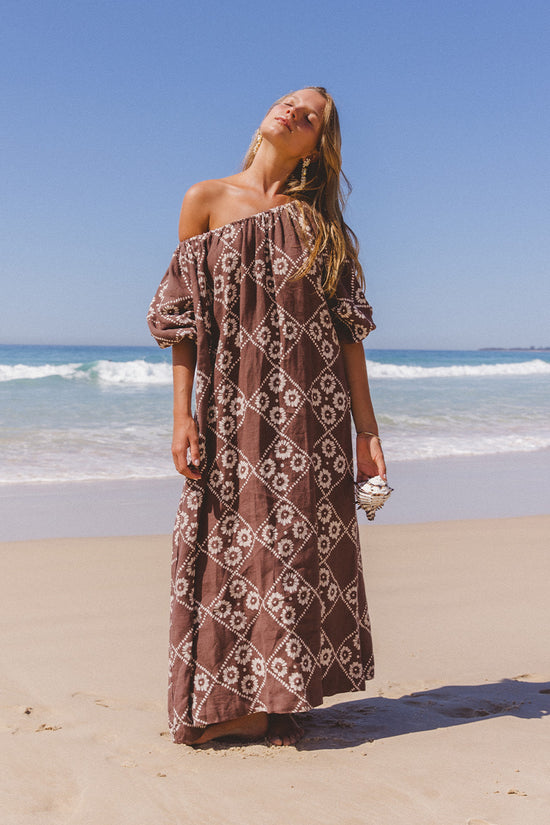 Dahlia Maxi Dress Maple — hand block print linen maxi, off-shoulder at beach, warm maple brown floral motif | Daughters of India