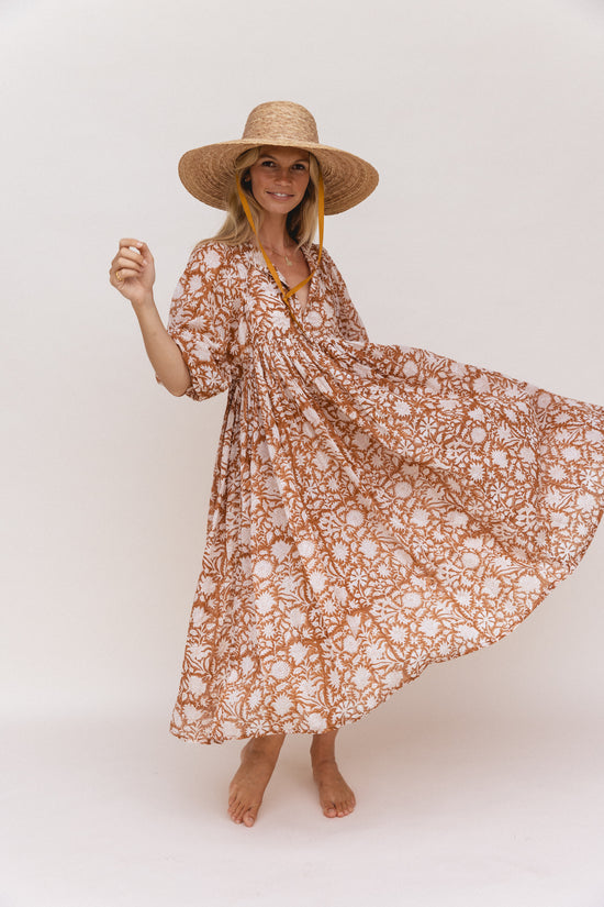 Daughters of India Kyra Midi Dress in Caramel — studio twirling with straw hat, flowing hand screen print skirt