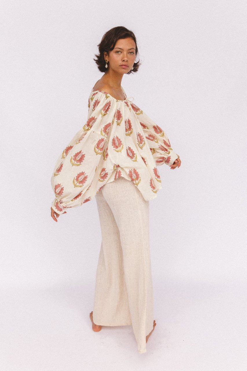 Ria Blouse Strawberry Cream — second lifestyle setting, model in garden or courtyard, strawberry cream hand block print cotton blouse | Daughters of India